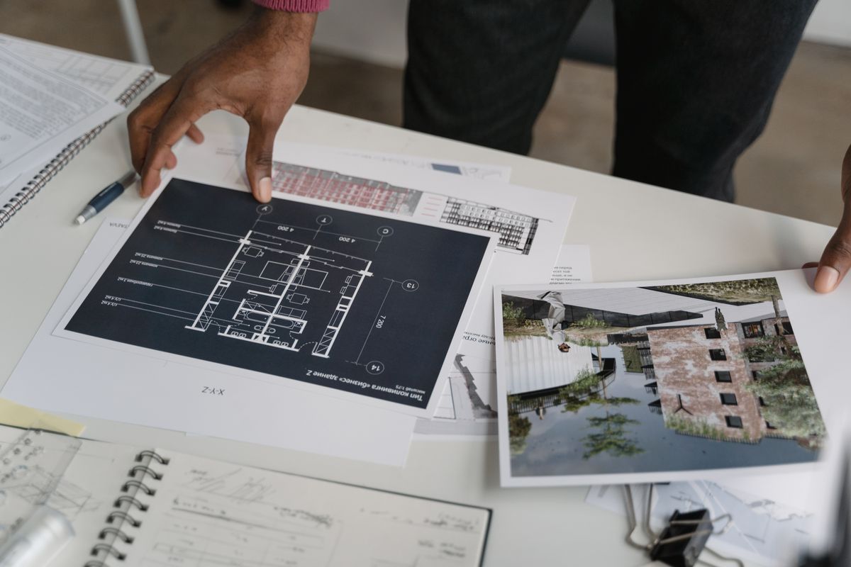 Manos revisando planos de obra sobre una mesa