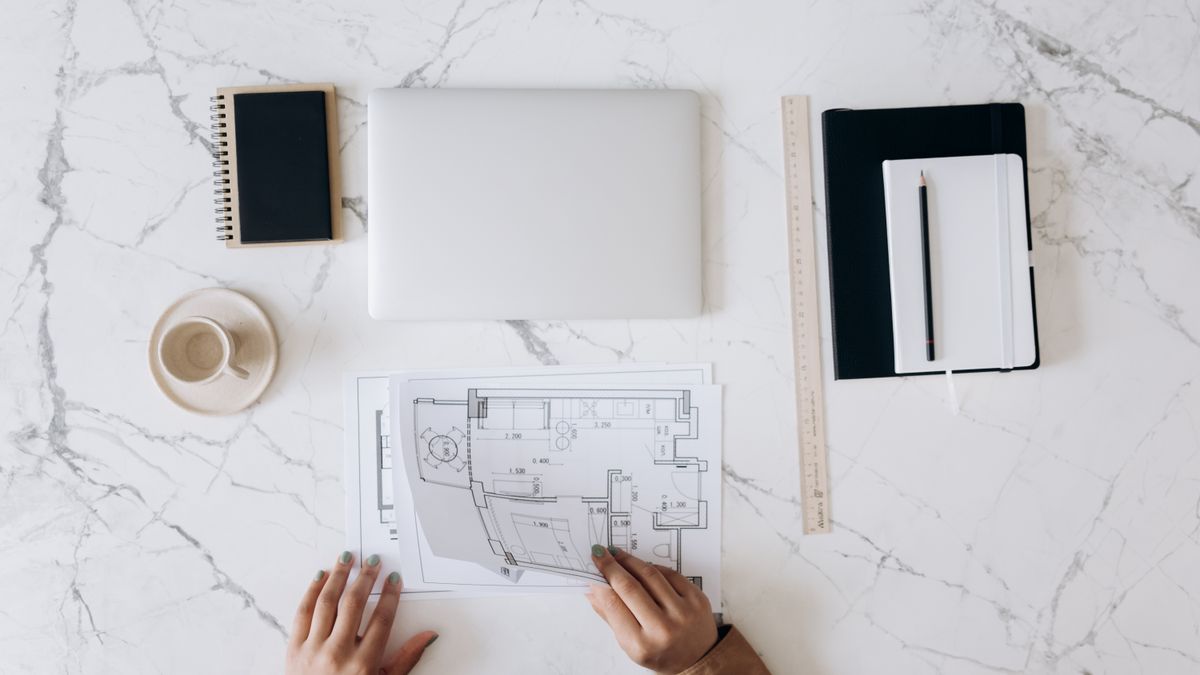 Mesa de trabajo con planos y regla